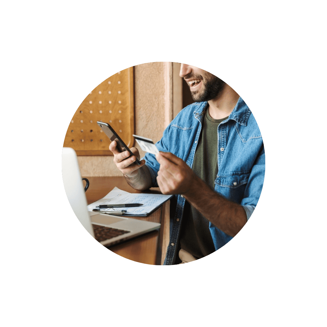 Uomo felice che utilizza smartphone e carta di credito per acquisti online.